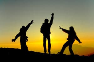 silhouette of three people at sunset